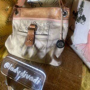 The SAK  two tone leather purse with adjustable woven strap.